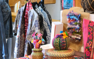 A vibrant display of colorful textiles, woven baskets, and handcrafted items showcasing diverse cultural artistry just like our veranda sale