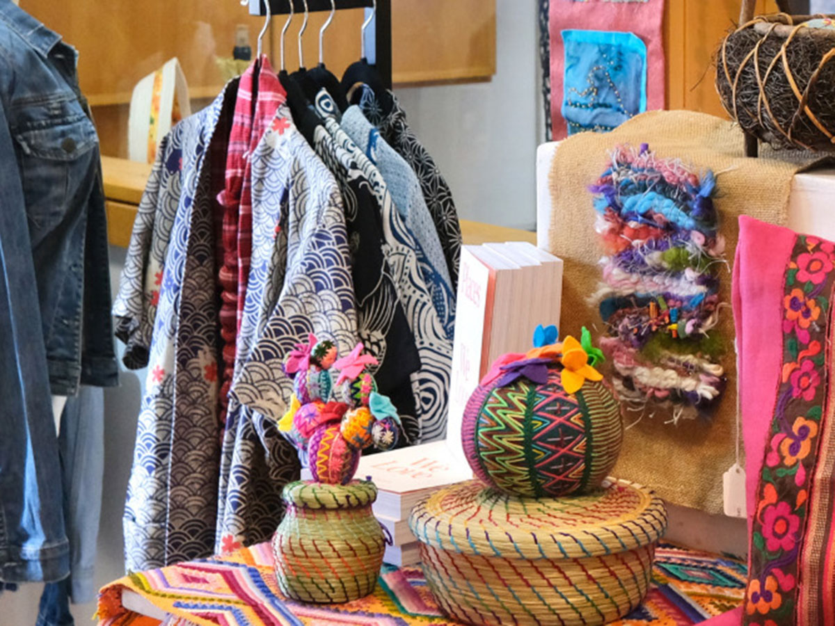 A vibrant display of colorful textiles, woven baskets, and handcrafted items showcasing diverse cultural artistry.