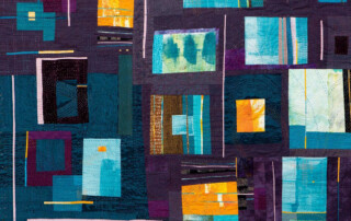 A vibrant quilt featuring a patchwork of teal, blue, and purple fabrics, with geometric shapes and textured stitching.
