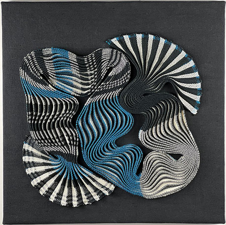 Abstract artwork featuring swirling, layered fabric patterns in black, grey, white, and blue against a dark background. Abstract artwork featuring swirling, layered fabric patterns in black, grey, white, and blue against a dark background.