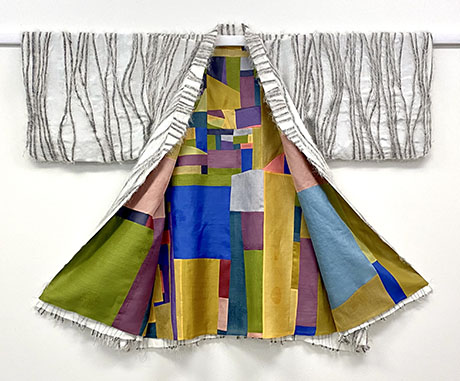 A uniquely designed kimono with a textured white outer layer featuring abstract patterns and a vibrant, geometric multicolored interior. A uniquely designed kimono with a textured white outer layer featuring abstract patterns and a vibrant, geometric multicolored interior.