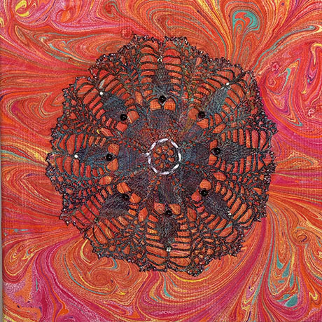 Intricate black lace doily with beadwork on a vibrant marbled background of swirling reds, oranges, and blues, creating a rich, psychedelic effect.