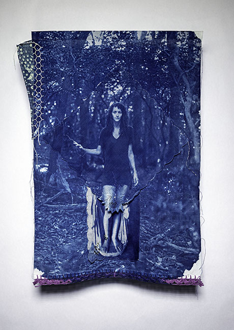 A textured artwork shows a woman in a forest, rendered in blue tones. The image is partially torn and layered on fabric, conveying a mysterious, ethereal mood.