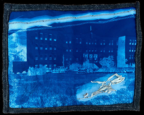 Blue-toned cyanotype print featuring a large building, chain patterns above, and a textured object in the foreground. The tone is artistic and abstract.