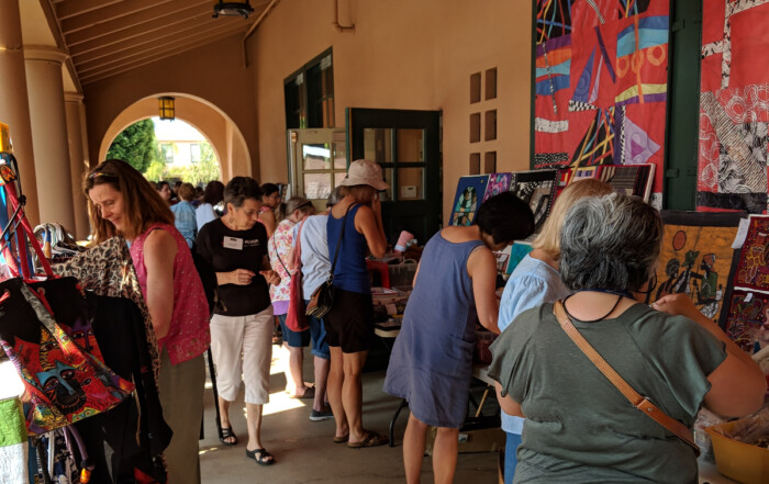 A vibrant display of colorful textiles, woven baskets, and handcrafted items showcasing diverse cultural artistry just like our veranda sale
