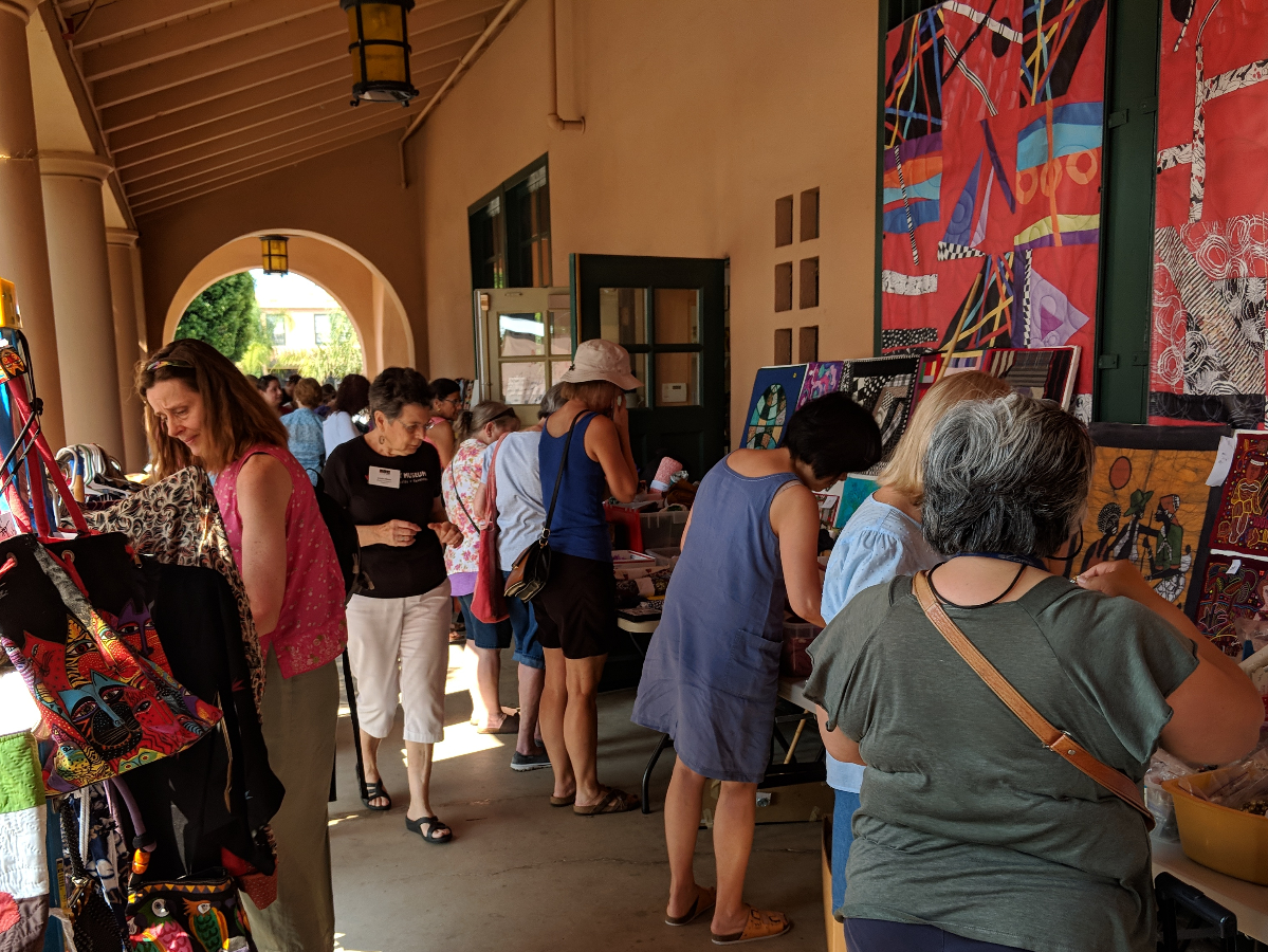 A vibrant display of colorful textiles, woven baskets, and handcrafted items showcasing diverse cultural artistry just like our veranda sale