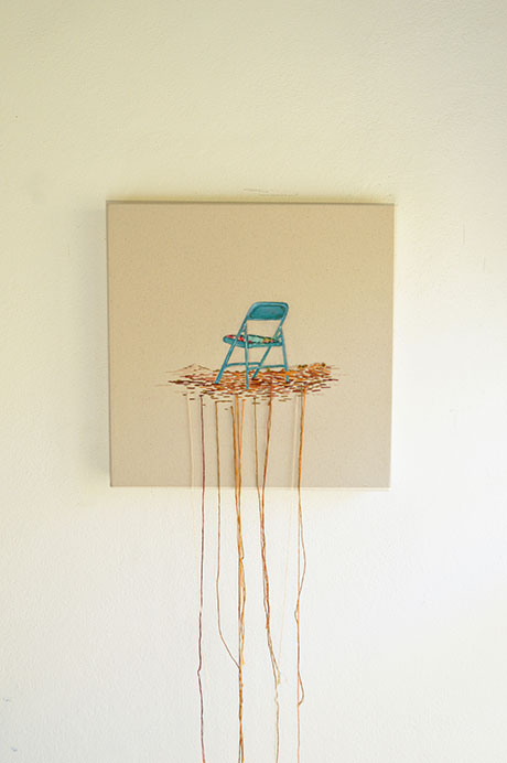 Artwork of a blue folding chair sitting on a patch with threads hanging down from the canvas onto a white wall. Artwork of a blue folding chair sitting on a patch with threads hanging down from the canvas onto a white wall.