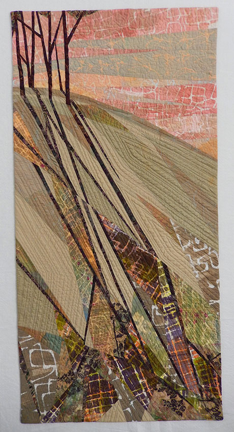 Abstract quilt art depicting trees and their long shadows cast on a textured hillside under a pink and orange sky. Abstract quilt art depicting trees and their long shadows cast on a textured hillside under a pink and orange sky.