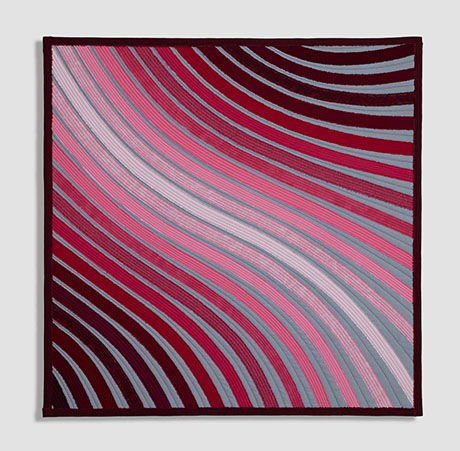 Abstract textile artwork with curved stripes in shades of pink, red, and gray, framed with a dark burgundy border. Abstract textile artwork with curved stripes in shades of pink, red, and gray, framed with a dark burgundy border.