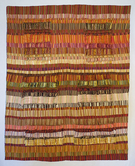 Colorful patchwork textile with horizontal and vertical stripes in earth tones, accented by textured, ruffled fabric sections. Colorful patchwork textile with horizontal and vertical stripes in earth tones, accented by textured, ruffled fabric sections.