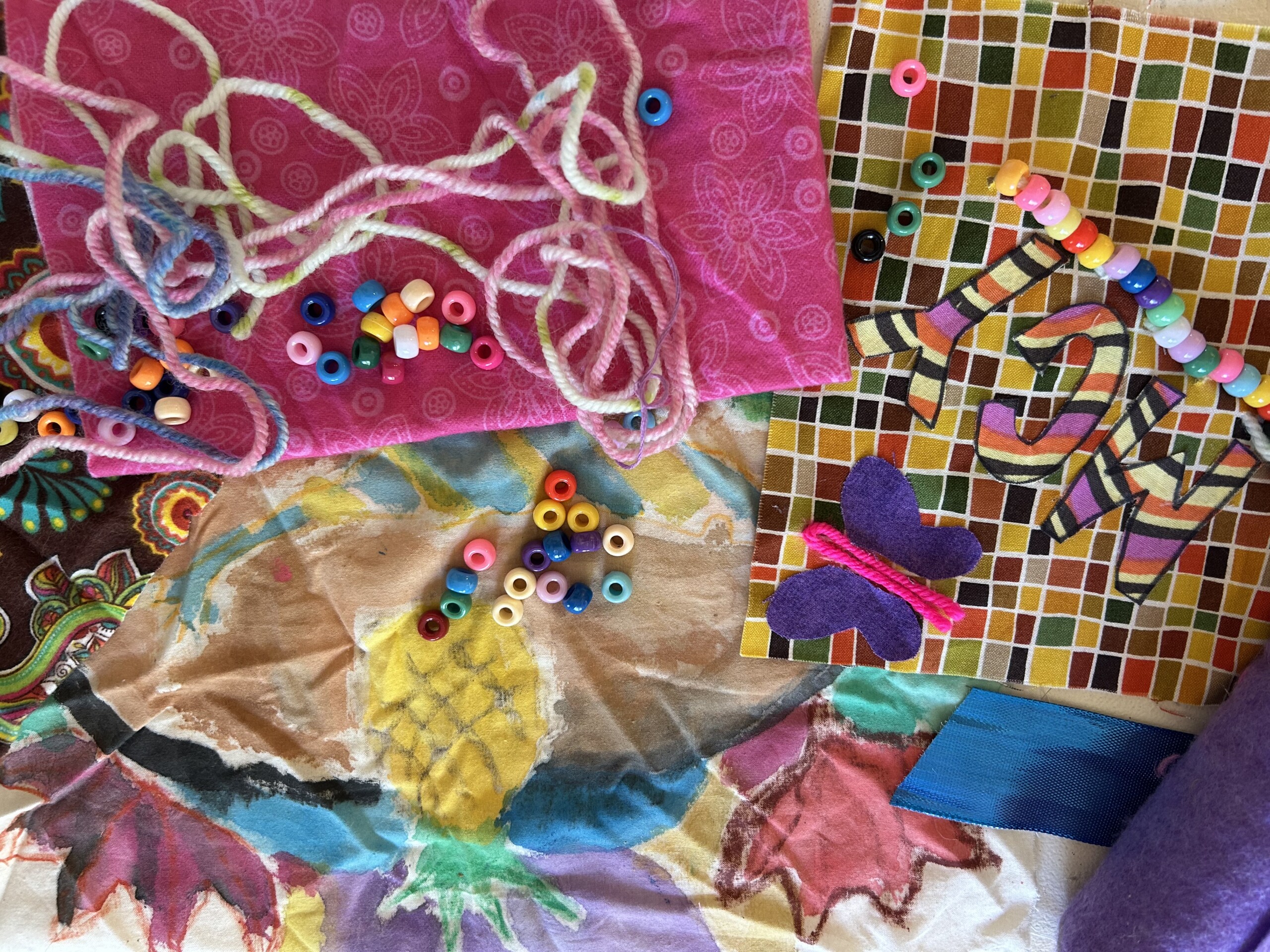 Story Tiles Colorful fabrics, thread, and beads.